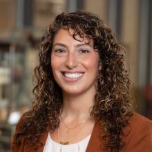 Tonia Guida Headshot with curly hair and burgundy blouse
