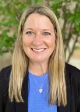 Angie House with straight, blonde hair and a blue shirt and black blazer