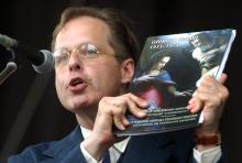 person holding book next to microphone