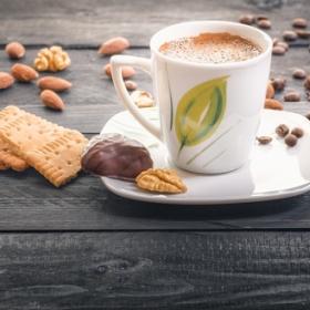 Close up of a coffee cup with assorted snacks