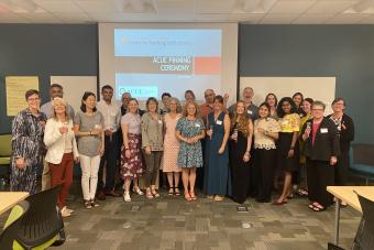 Large of individuals standing in front of a digital projection screen